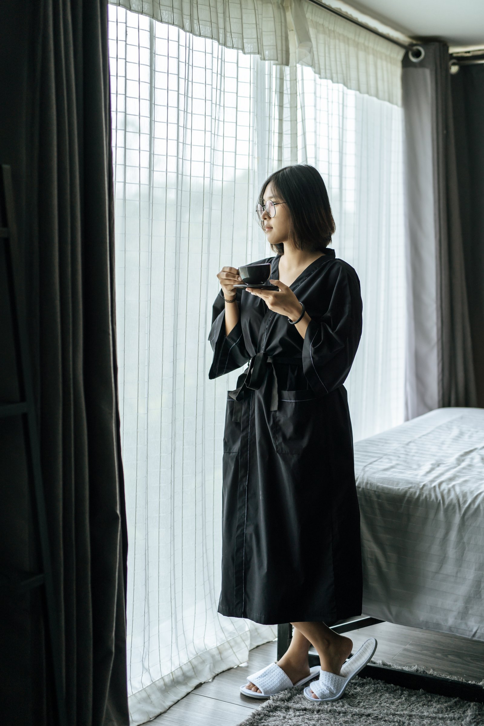 Women wearing black robes, handing coffee in the bedroom.